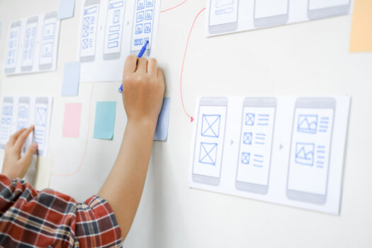 A man drawing a UX design on a white board.
